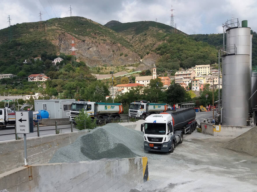 Mezzi pesanti e camion telonati all'interno dell'impianto ASTER per la produzione di conglomerati bituminosi